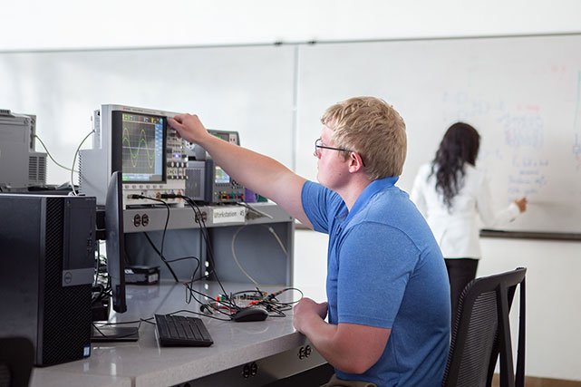 UCCS engineering student with faculty member in background