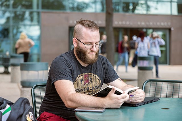 UCCS student studying in front of the engineering building