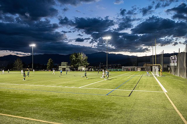 UCCS soccer team playing on field at sunset
