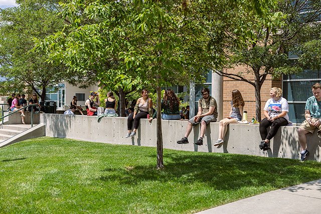 UCCS students sitting on wall on campus