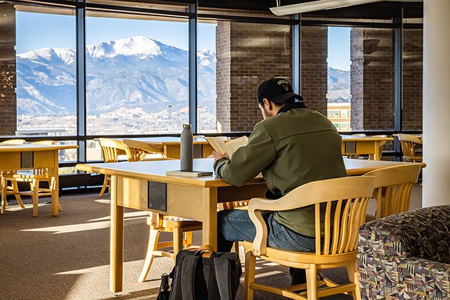 UCCS student studying with Pikes Peak in the background