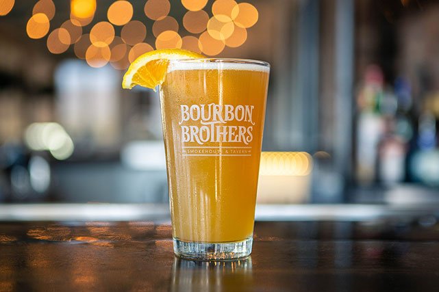 Bourbon Brothers branded pint glass full of beer