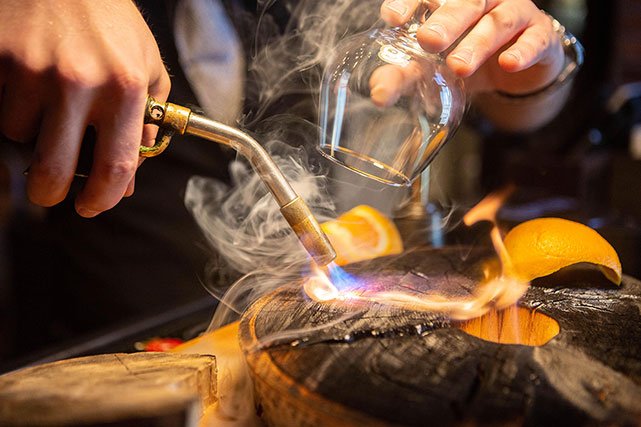 Bourbon Brothers bartender making smoked drink