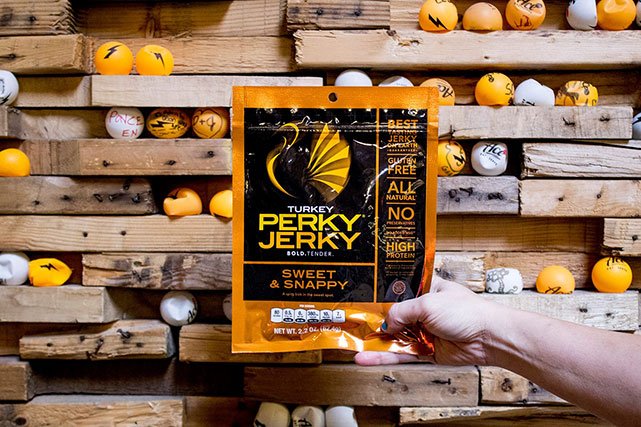 Perky Jerky being held in front of ping poing wall